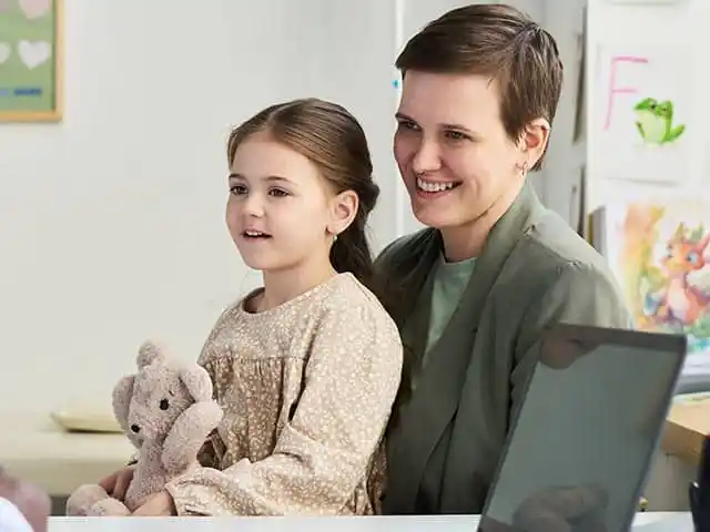 Mutter mit Kind im Beratungsgespräch, das Mädchen hält ein Kuscheltier